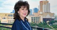 A sideview of Professor Elizabeth Lee resting an arm against a rail at Sunway University’s Rooftop Terrace overlooking the SCKL cityline