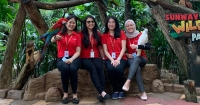 Donned in Sunway signature red polo, the four ladies who make up Sunway Group Sustainability Department sit side-by-side, posing with the parrots at Sunway Lagoon Wildlife Park during daytime