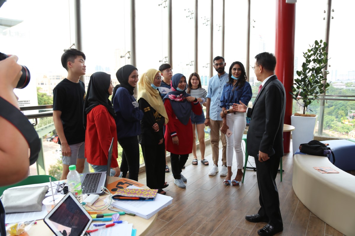 A wide shot of Tan Sri Dr. Jeffrey Cheah interacting with some students of Sunway University at the Rooftop Terrace of Sunway University.