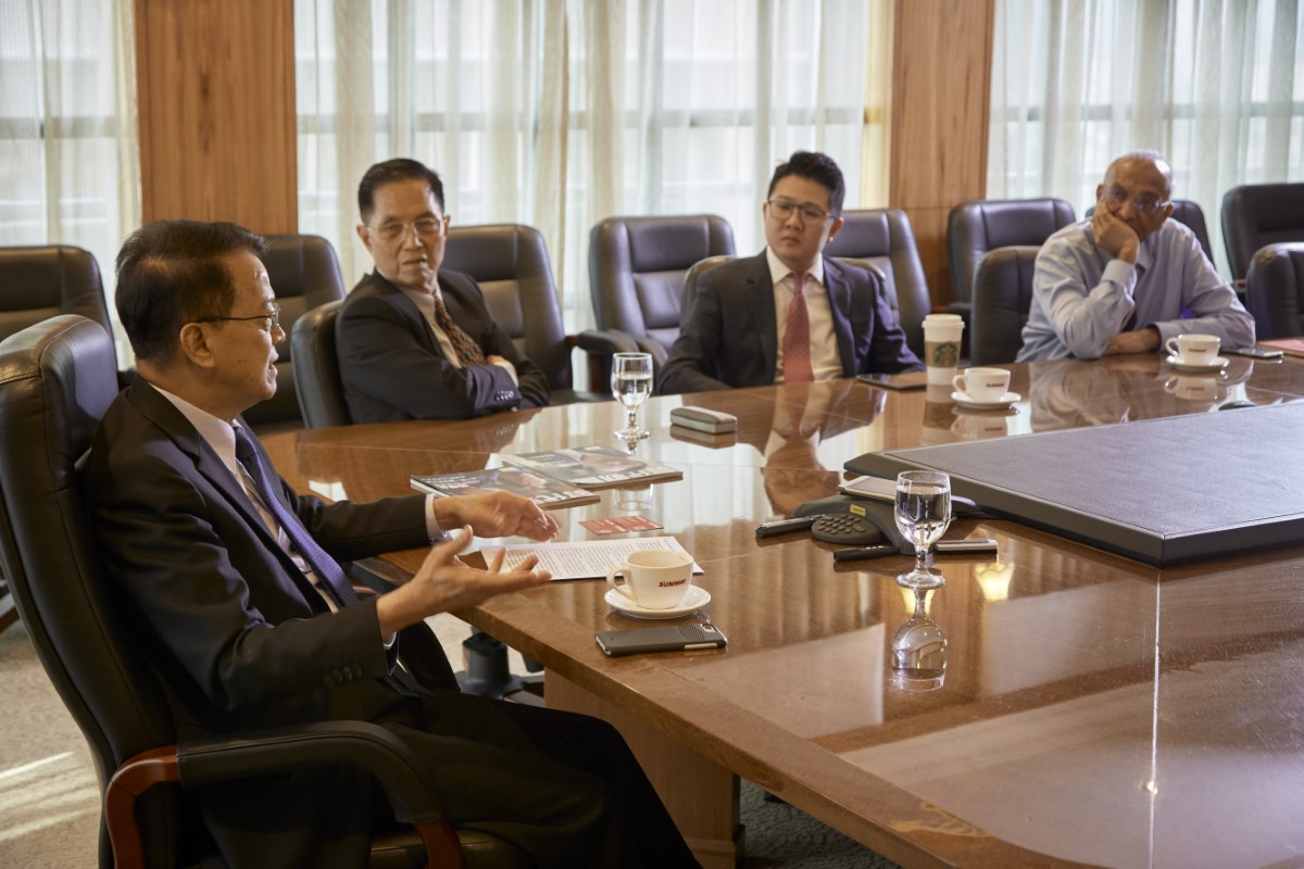 A mid shot of Tan Sri Dato’ Chew Chee Kin, Yap Shi Han and Raman Narayanan looking at Tan Sri Dr. Jeffrey Cheah, all seated side-by-side in the Board of Director’s meeting room