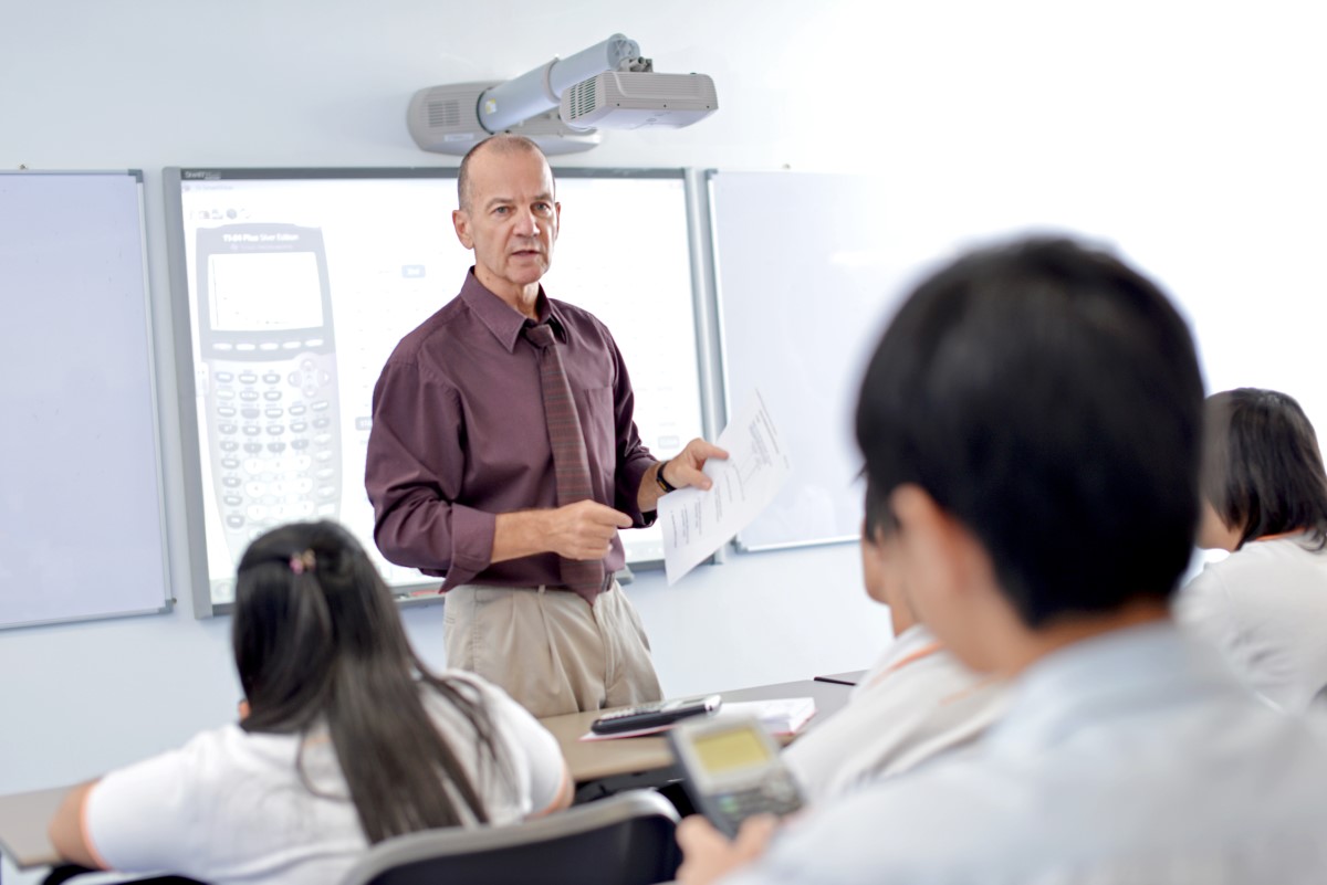 A male teacher giving a lecture to his students