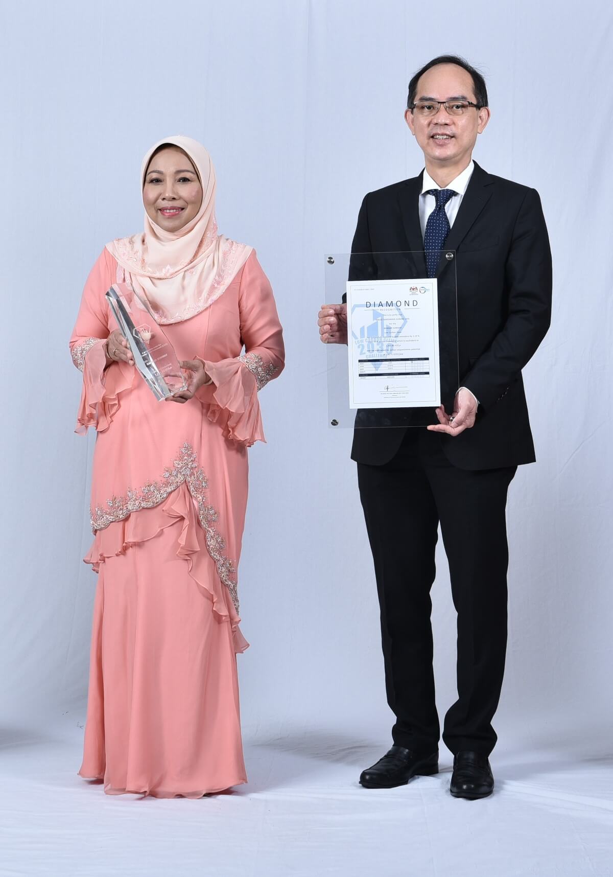 Mayor of Subang Jaya Noraini Binti Roslan and Sunway Property Management Division Senior General Manager holding the Low Carbon City Diamond Recognition trophy and certificate respectively