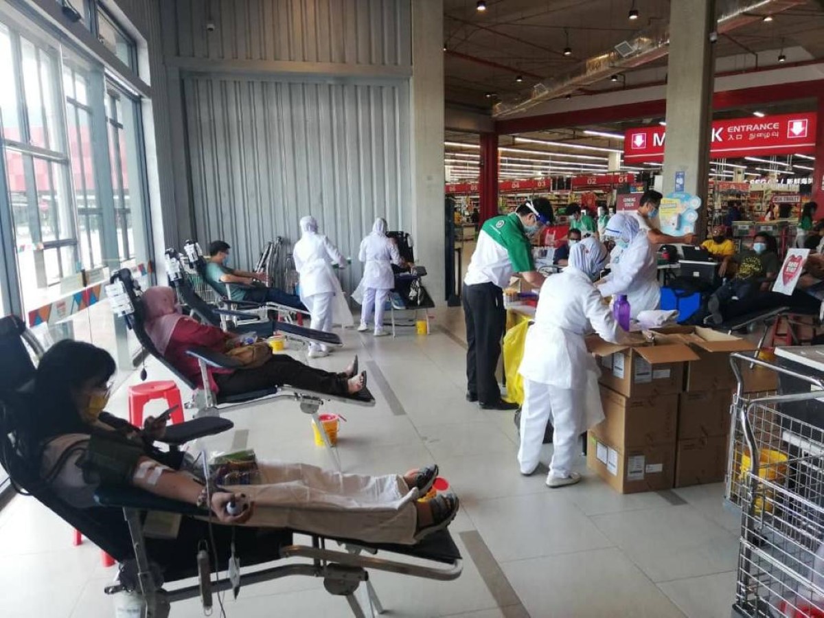 A wide shot of stations of a blood donation drive located at indoor high traffic areas such as opposite hypermarkets