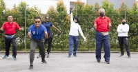 A wide shot of six employees performing physical exercises