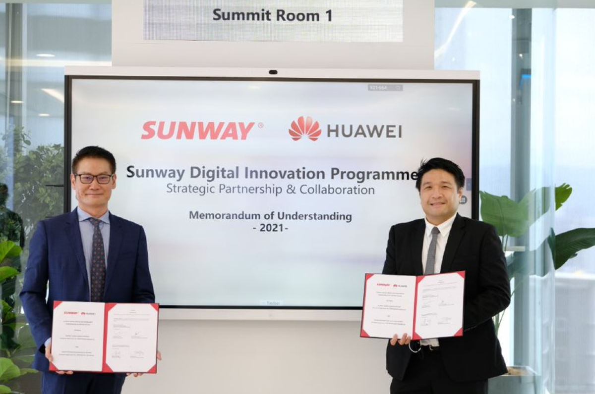 A mid-shot of Huawei Malaysia CEO Michael Yuan standing in a safe distance away from Sunway Group CIO Kevin Khoo – both holding their copies of Memorandum of Understanding 2021, sealing the Sunway x Huawei Strategic Partnership & Collaboration