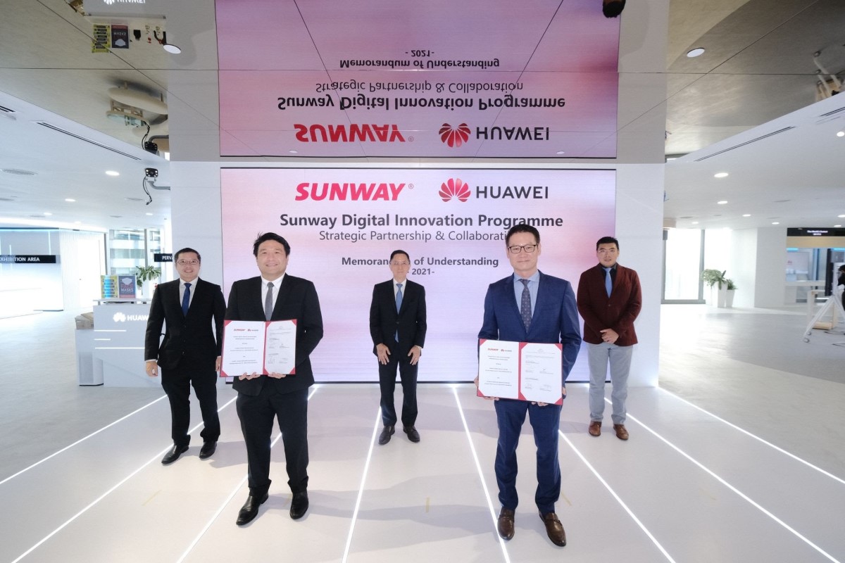A wide shot of spokesperson and representatives from Sunway Group and Huawei Malaysia, each standing in safe distances away from each other in a bright space