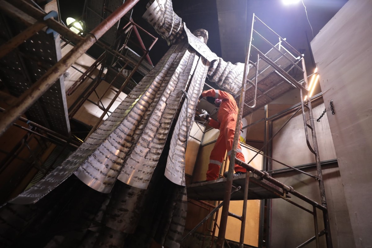 A low-angle wide shot of Infantino at work during the earlier stages of putting together sculpture ‘Destiny’ on tall steel structures