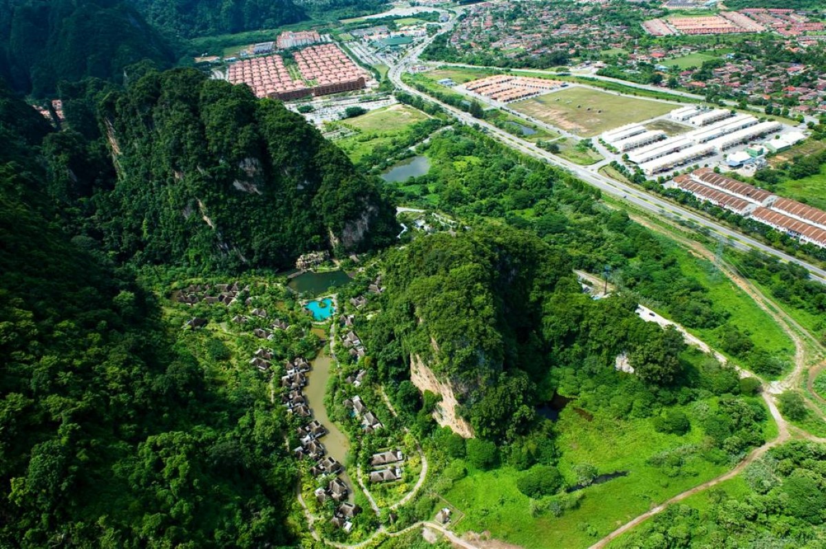 An aerial view of the 260-million-year-old limestone hill and luscious greenery around surrounding The Banjaran Hotsprings Retreat, with Sunway City Ipoh in the vicinity.