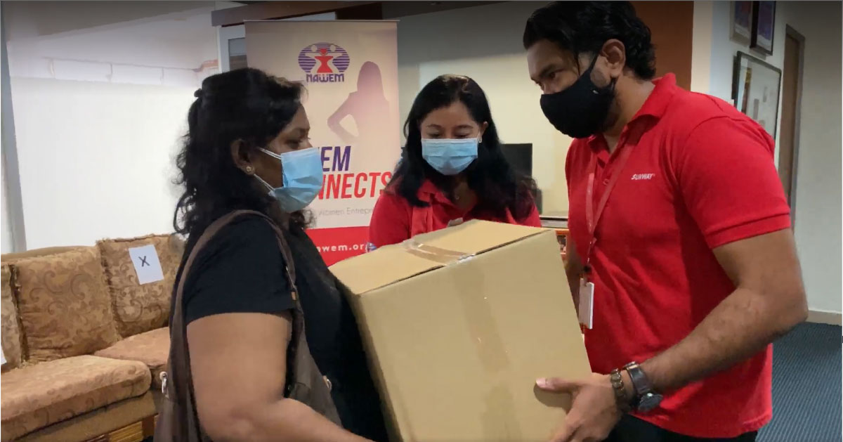 Our Sunway staff alongside the representative of NAWEM giving the box to a beneficiary