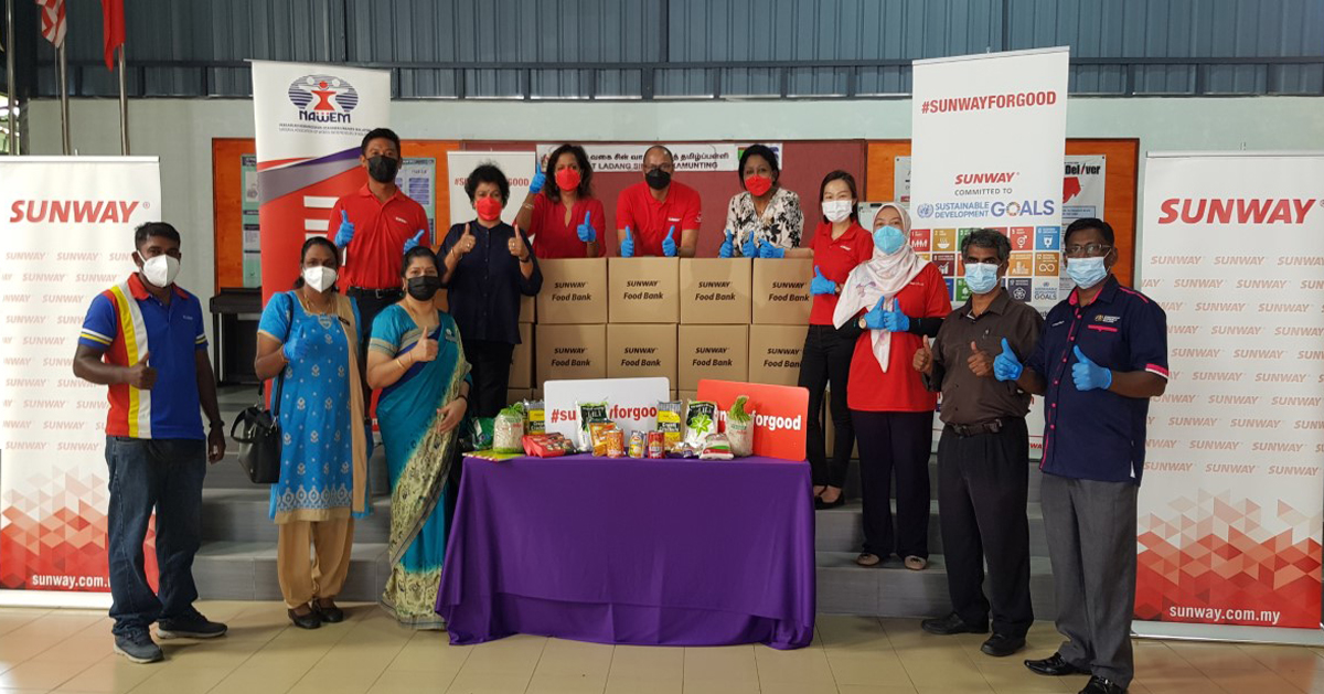 Sunway staff giving a thumbs up as we reach out with essential items to the beneficiaries