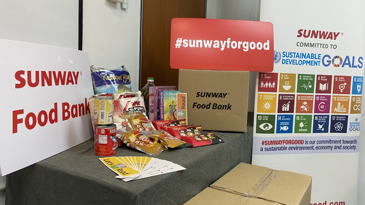 A shot of the essential items with the #SunwayforGood Food Bank box, alongside the Sunway banner featuring the United Nations Sustainable Development Goals