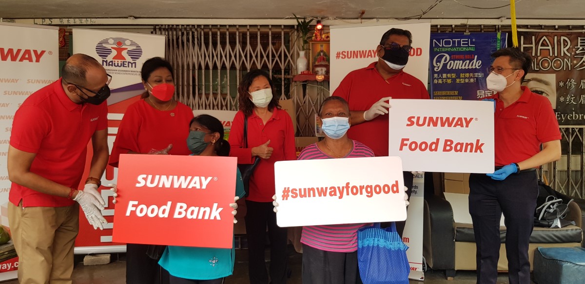 Our Sunway staff posing with the #SunwayforGood cutouts with happy beneficiaries
