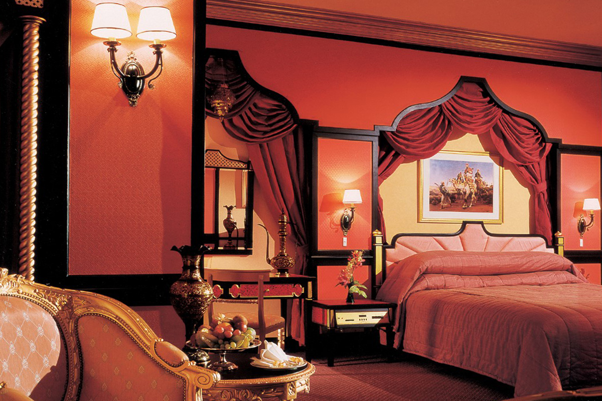 A close-up shot of Sunway Resort’s Arab-themed room, featuring red and warm hues, velvet duvets, outlined with black and gold accents.
