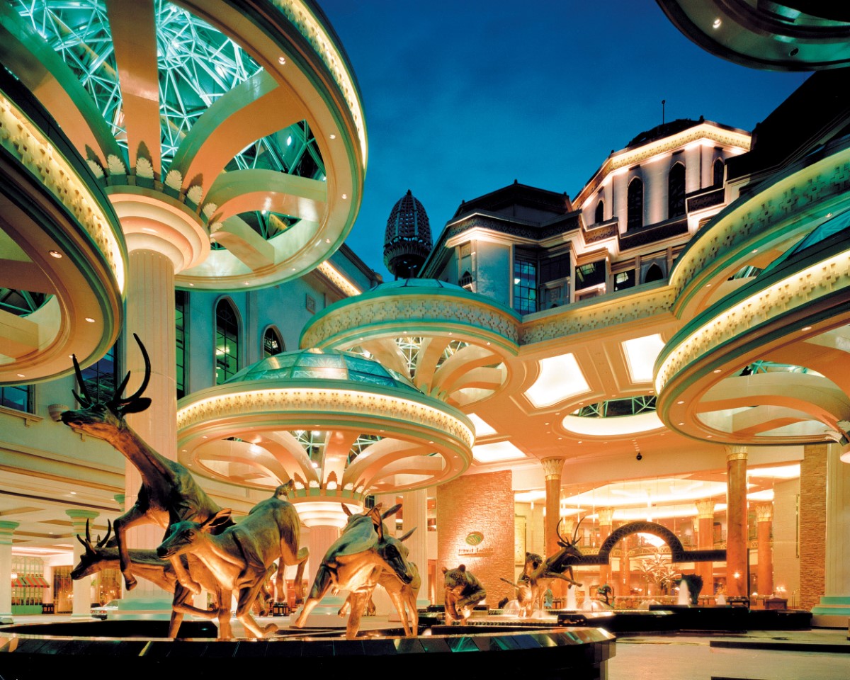 A wide angle shot of a brightly lit entrance to Sunway Resort, the lifelike sculpture of a tiger in pursuit of a herd of trampling deers taking centerstage.
