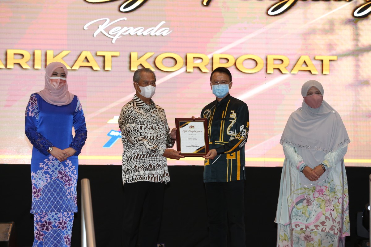 A medium full landscape shot of Sunway Group founder and chairman Tan Sri Dr. Jeffrey Cheah AO receiving a prestigious recognition from the Department of Social Welfare Malaysia at its 75th Anniversary Celebration from former Prime minister, Tan Sri Muhyiddin Yassin