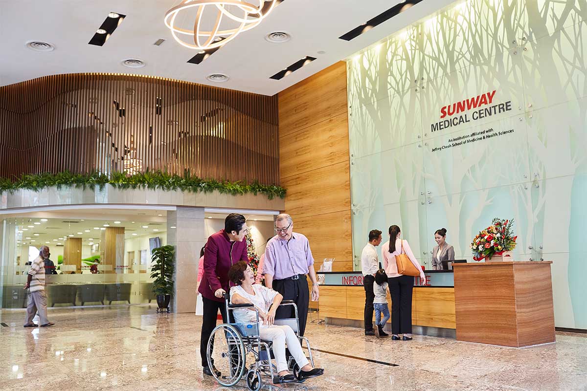 Facade of Sunway Medical Centre featuring patient in wheelchair and doctors