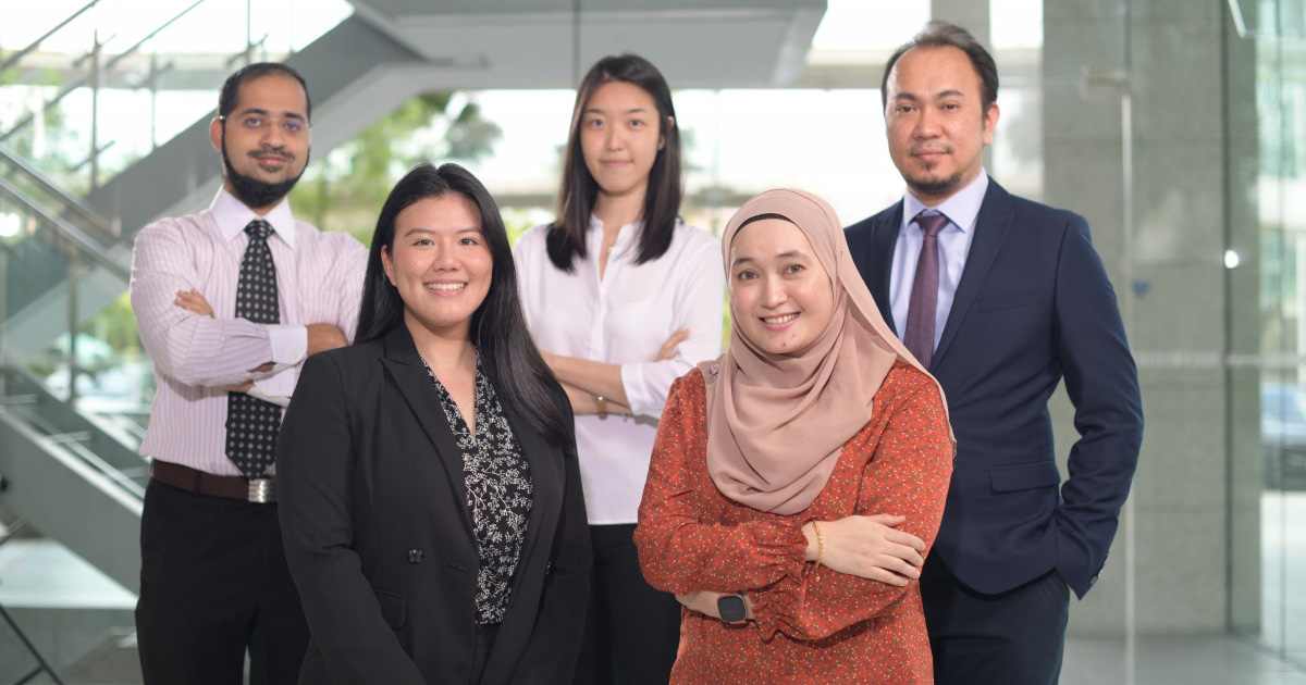 Five Sunway employees of different ethnicities stand together for a picture.