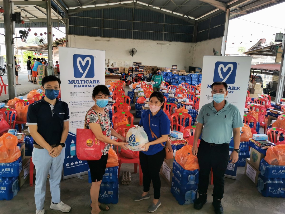A high wide angle shot of representative of Sunway Group member Multicare Pharmacy handing over enclosed bags of essential goods to fire victims in Karak who lost their homes and businesses in a blaze, while Multicare pharmacists and pharmacy assistants extended help and comfort to the victims and rescue team through their Disaster Relief programme
