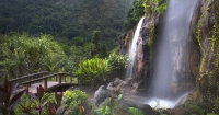 A wide angle shot of Banjaran Hot Springs Retreat in Ipoh, Perak, with its colour saturation manipulated to present a majestic allure, its lush greenery sharpened and waterfall tinged with a pastel blue and pink at the far right corner.