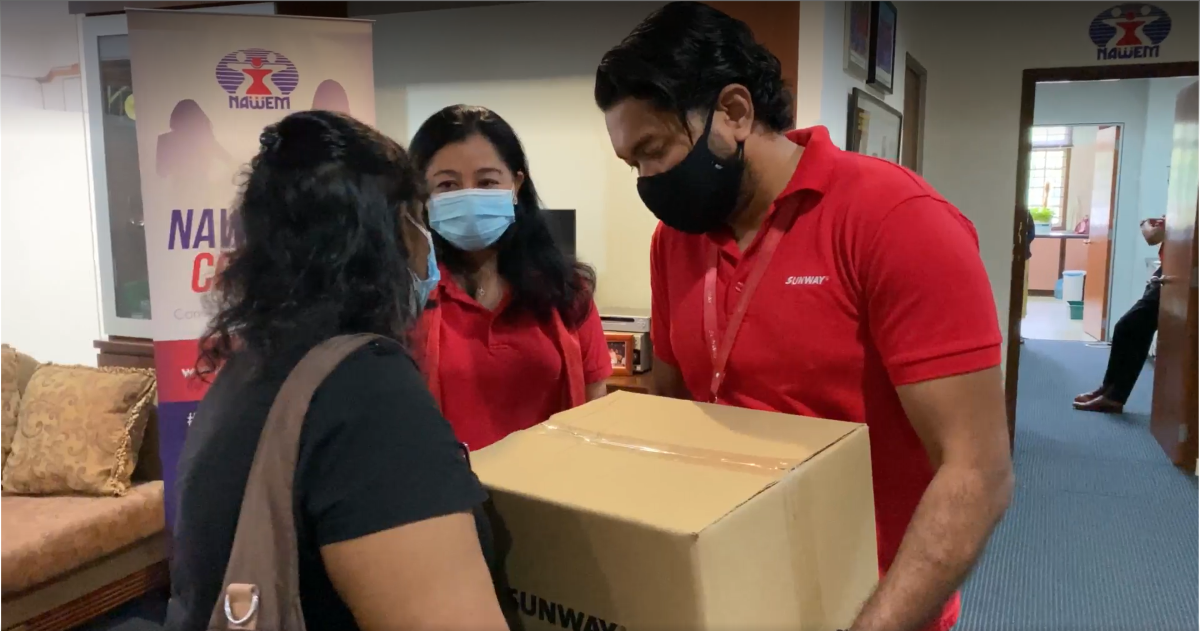 Our Sunway staff alongside the representative of NAWEM giving the box to a beneficiary