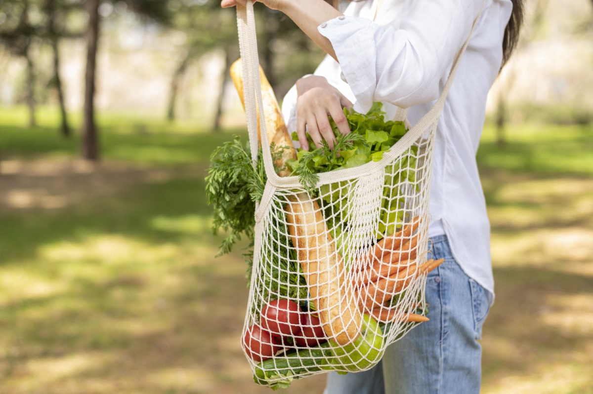 Lady bringing a reusable cloth bag buying vegetables
