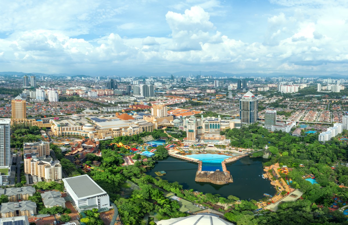 A bird’s eye landscape shot of midday Sunway City Kuala Lumpur in its full glory – with Sunway Lagoon Theme Park taking center stage, surrounded by natural greenscapes and SCKL city line view with clear sky looming ahead