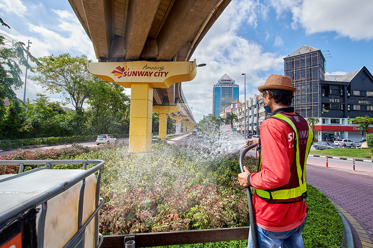 A side-angle shot of farmer watering the plants in Sunway City Kuala Lumpur