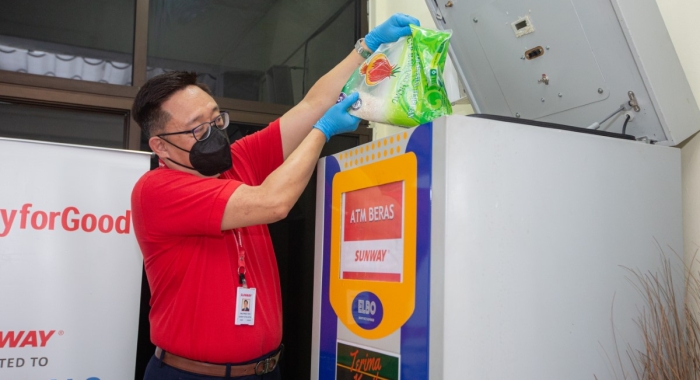 A medium full landscape shot of Sunway Hotel and Resorts’ senior group general manager Wilfred Yeo refilling rice into one of our many rice ATMs located within Selangor.