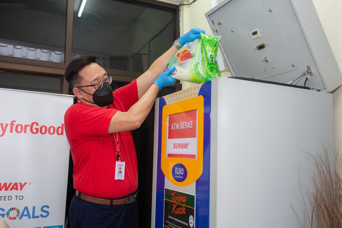 A medium full landscape shot of Sunway Hotel and Resorts’ senior group general manager Wilfred Yeo refilling rice into one of our many rice ATMs located within Selangor.