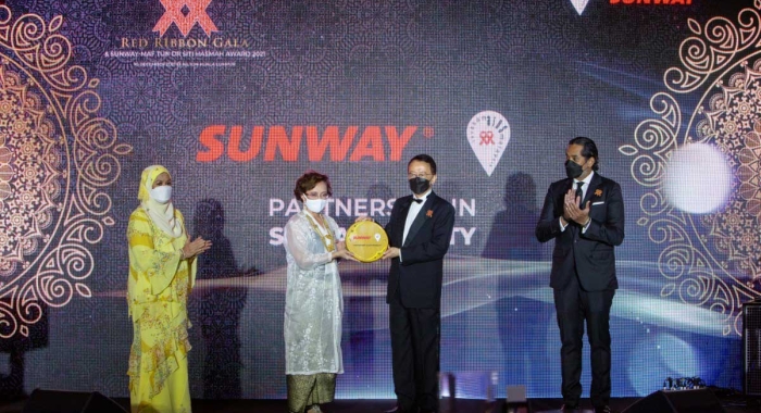 A full landscape shot of Sunway Group founder and chairman Tan Sri Dr. Jeffrey Cheah AO alongside MAF chairman Professor Dato’ Dr. Adeeba Kamarulzaman presenting the Sunway-MAF Tun Dr. Siti Hasmah Award during Malaysian AIDS Foundation’s Red Ribbon Gala 2021, witnessed by Malaysia’s Minister of Health in the Federal Government Khairy Jamaluddin