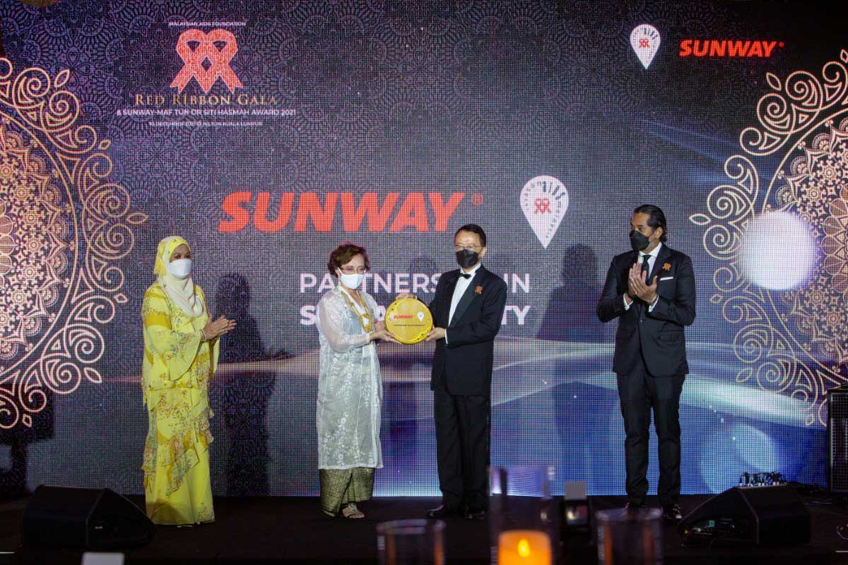 A full landscape shot of Sunway Group founder and chairman Tan Sri Dr. Jeffrey Cheah AO alongside MAF chairman Professor Dato’ Dr. Adeeba Kamarulzaman presenting the Sunway-MAF Tun Dr. Siti Hasmah Award during Malaysian AIDS Foundation’s Red Ribbon Gala 2021, witnessed by Malaysia’s Minister of Health in the Federal Government Khairy Jamaluddin