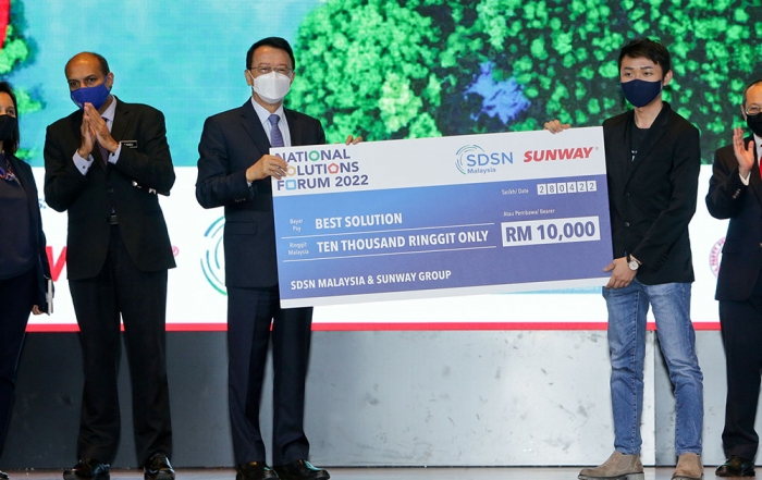 Tan Sri Sir Jeffrey Cheah (left) presenting a mock cheque to Powered by RISE founder Kray Chong’s (right) best Wellbeing-themed solution for the National Solutions Forum 2022.