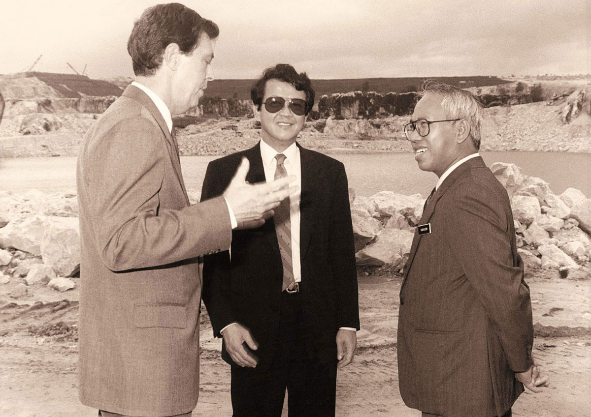 Tan Sri Dr. Jeffrey Cheah alongside two other men in a black and white picture, amidst the landscape of a derelict wasteland background of Sunway City Kuala Lumpur