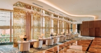 Front desk staff of Sunway Resort amidst a glittering golden backdrop, with marbled and carpeted floors that exudes grandeur.