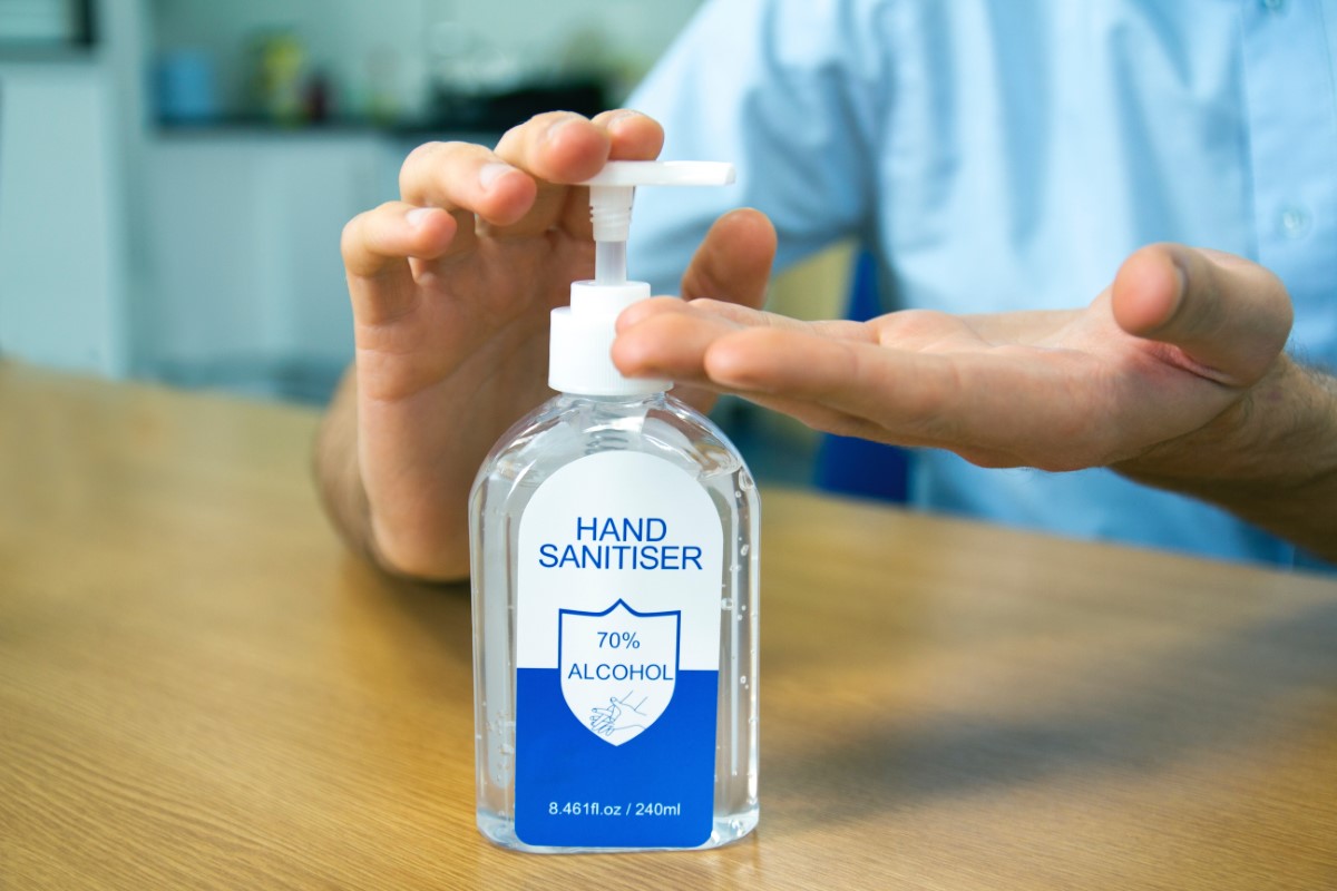 Close-up shot of individual sanitising hands with hand sanitiser