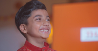 The talent of Sunway’s ”Let Light Lead the Way” video, Kishen – an Indian boy wearing a red kurta – smiles with his gaze elsewhere.