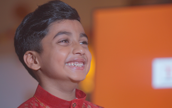 The talent of Sunway’s ”Let Light Lead the Way” video, Kishen – an Indian boy wearing a red kurta – smiles with his gaze elsewhere.