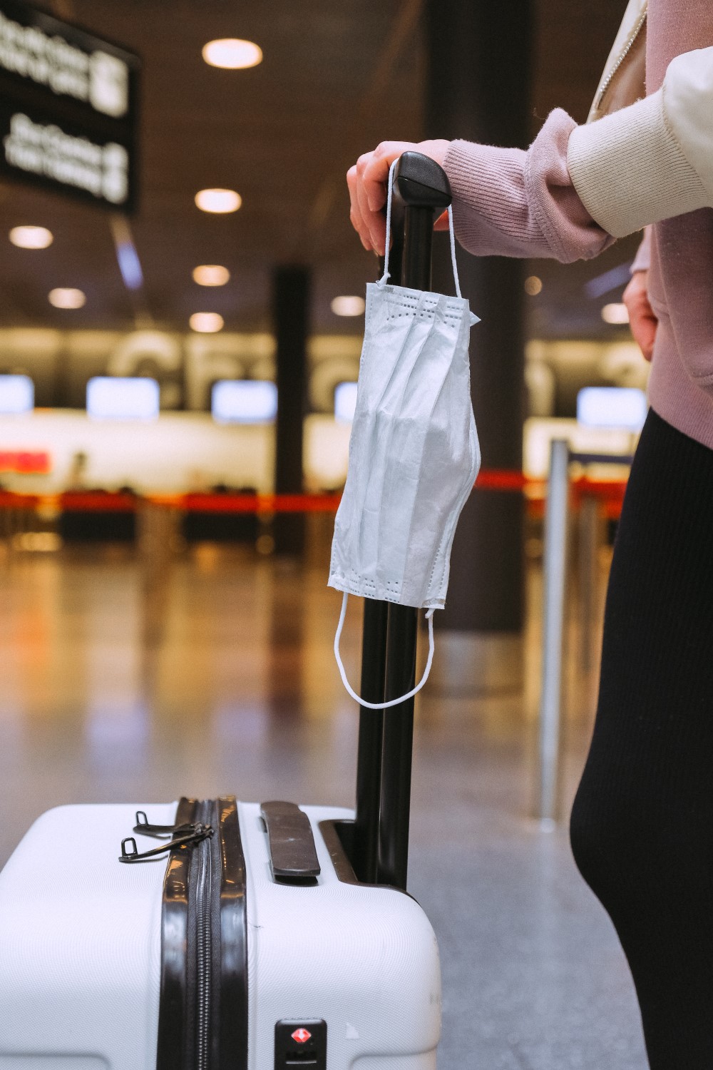 Mid shot of a face mask hanged on a luggage holder