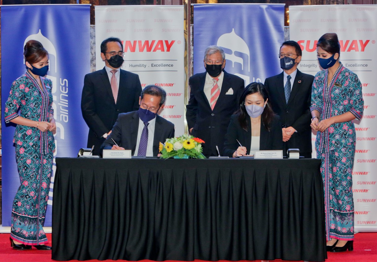 A full landscape shot of MAG’s Captain Izham Ismail and Sunway’s Sarena Cheah co-signing a MoU to seal the partnership.