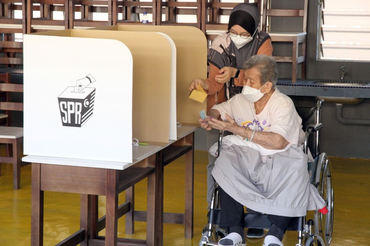 Candid shot of Malaysian woman on wheelchair casting her vote