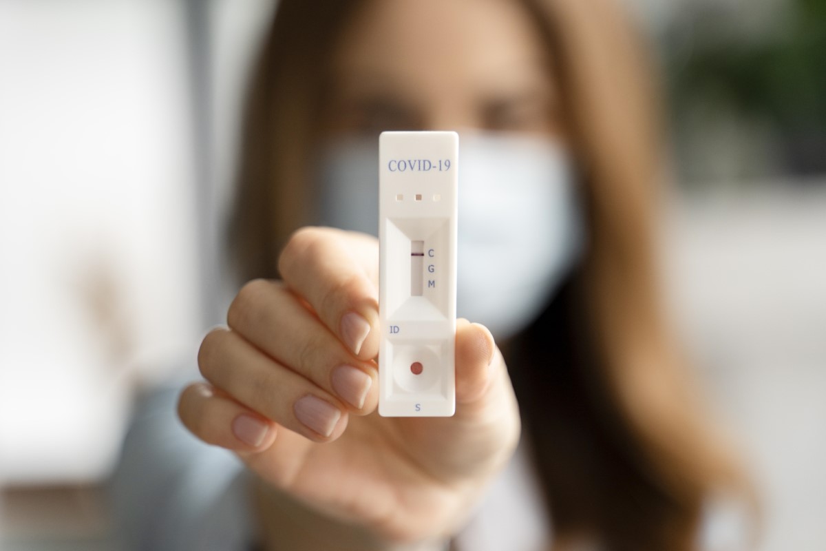 close-up shot of a lady with a saliva test kit