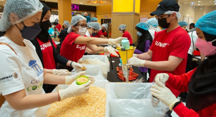 A medium landscape shot of Sunway volunteers in action during Sunway Meal Pack-a-Thon 2022 at Sunway Pyramid, Sunway City Kuala Lumpur.