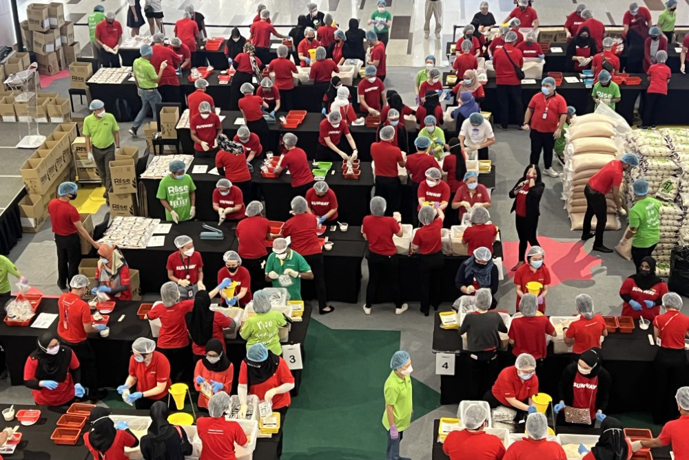 A high-angle landscape shot of Sunway volunteers in action during Sunway Meal Pack-a-Thon 2022 at Sunway Velocity Mall, Kuala Lumpur.