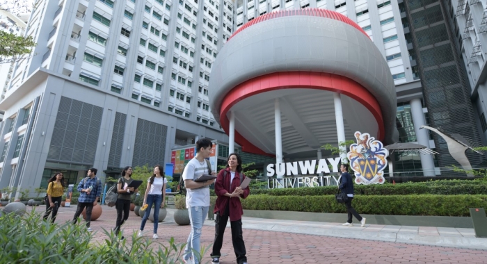 A full landscape shot of varsity students walking in front of Sunway University main building