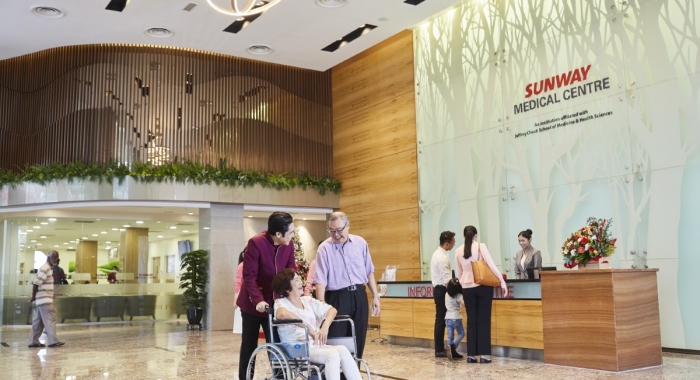 A full landscape shot of patrons in the grand lobby of Sunway Medical Centre, Sunway City Kuala Lumpur.