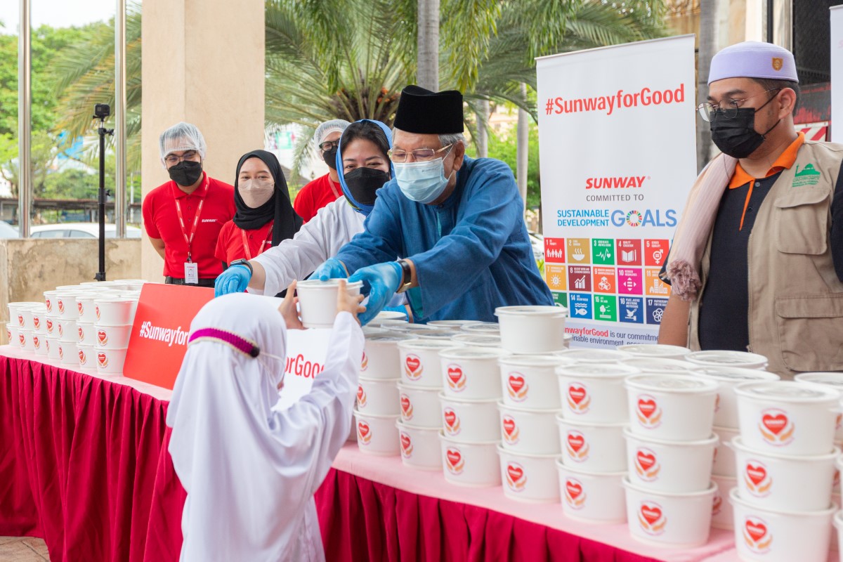 Tan Sri Razman, alongside Nik Tasha Nik Kamaruddin and other Sunway staff, providing bubur lambuk to a child in our #SunwayforGood programme