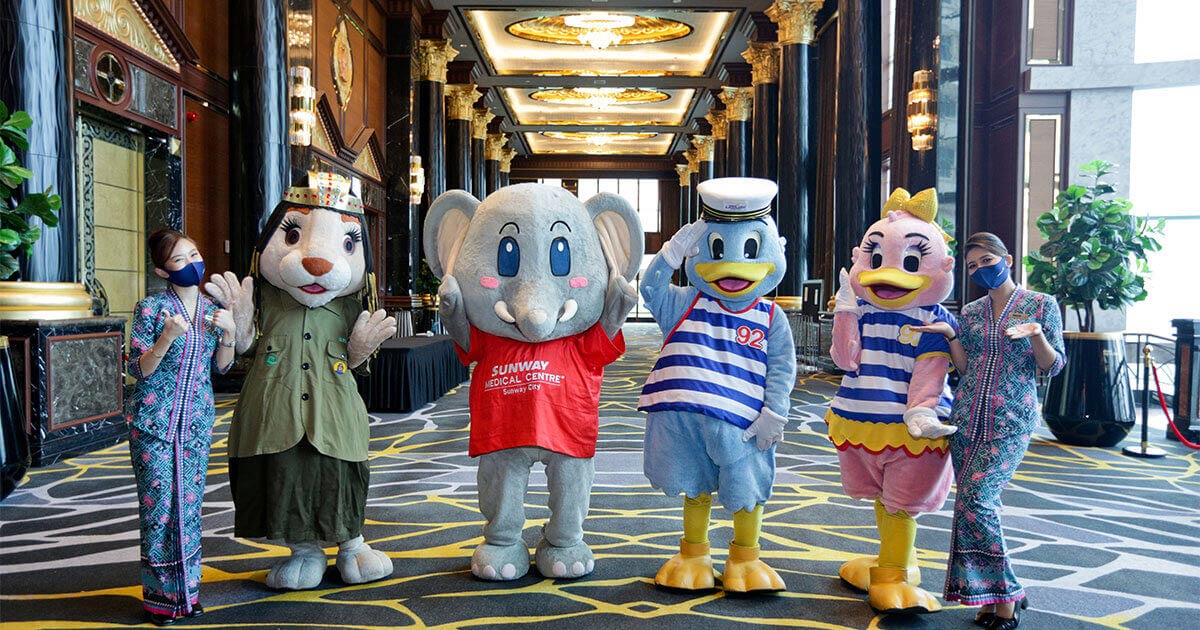 A full landscape shot featuring Sunway City Kuala Lumpur mascots – Leona representing Sunway Pyramid, Elfie representing Sunway Healthcare Group, and Captain Quack as well as Lady Quack representing Sunway Lagoon Theme Park, poised in between two Malaysia Airlines stewardesses in the lobby of Sunway Resort Hotel’s Grand Ballroom.