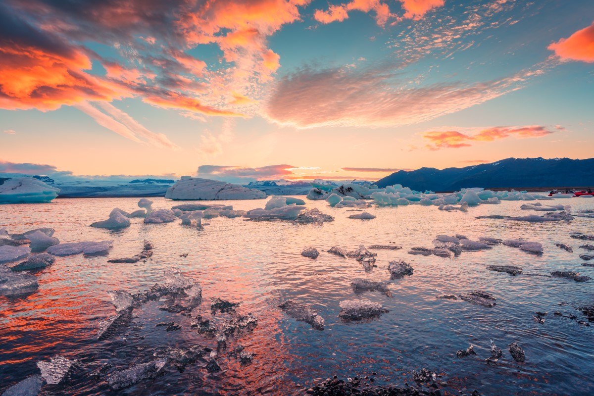 Sunset over iceberg and ice melting and floating in Jokulsarlon glacier lagoon Vatnajokull national park in Iceland.