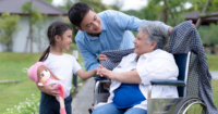 Candid shot of a man, a young girl and an elderly on wheel chair