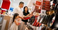 A candid shot of a family of three shopping for kitchen utensils